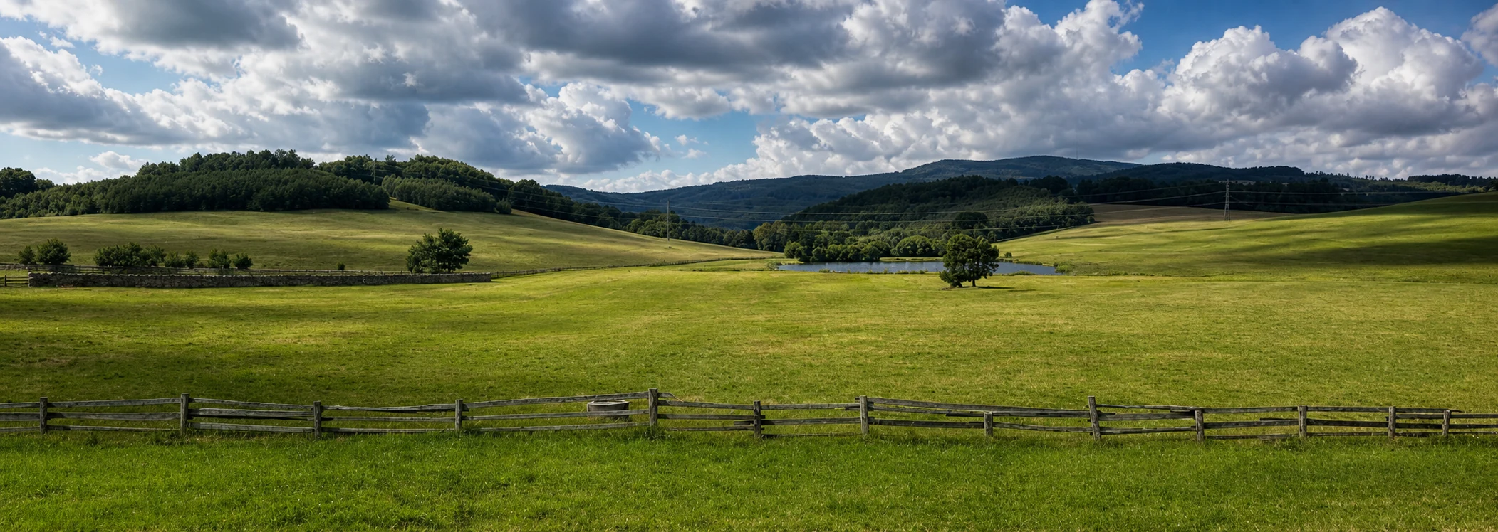 Krajina s loukami, rybníkem a kopci